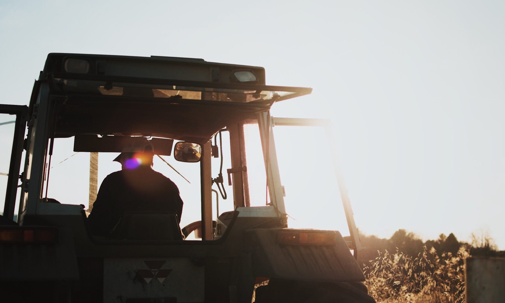 Bauer auf meinem Traktor im Sonnenschein